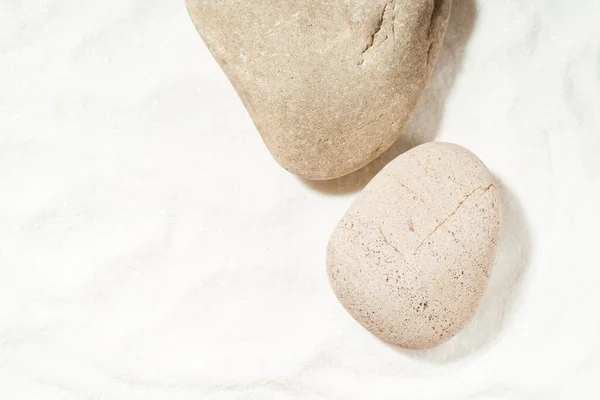 stock image Mockup scene with sea stones on a white sand background. Natural pedestal or stage for cosmetic product presentation or package advertisement. Copy space.