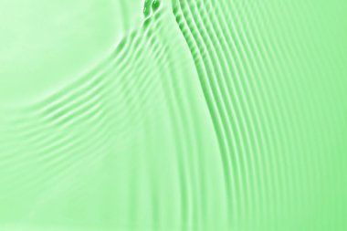 Narin yeşil su dokusu, ışık yansıması olan bir arka plan. Su yüzeyi maketi.