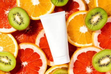 Boş beyaz krem tüp modeli ya da meyve dilimlerinin üzerinde duran kozmetik ürün şablonu. Üst görünüm.