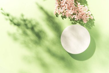 Ürün sunumu için boş beyaz daire maketi podyumu sertleştirilmiş bahar çiçeği arka planında sert ışıkla. Moda tasarımı düz ve kopyalama alanı var. Üst görünüm.