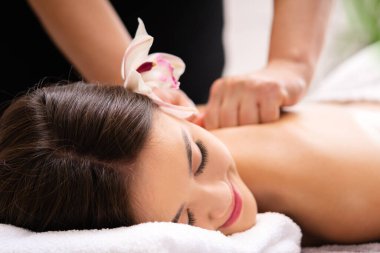 Masaj spa arka planında masaj salonunda dinlenen güzel Asyalı bir kadın. Yumuşak odak.