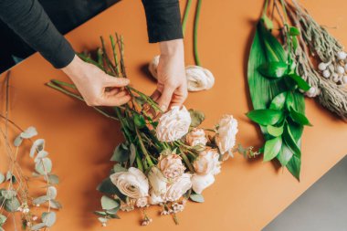 Çiçekçilik ve çiçekçilik. Çiçekçi şakayık gülleri ve ranunculusla çiçek aranjmanı yapar..