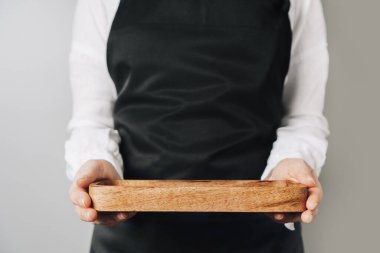 Cilt bakımı sunumu için boş ahşap maket podyumu tutan kadın..