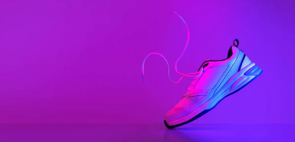 Λευκό Sneaker Αιωρείται Κατά Την Πτήση Αιωρούμενα Κορδόνια Νέον Φώτα — Φωτογραφία Αρχείου