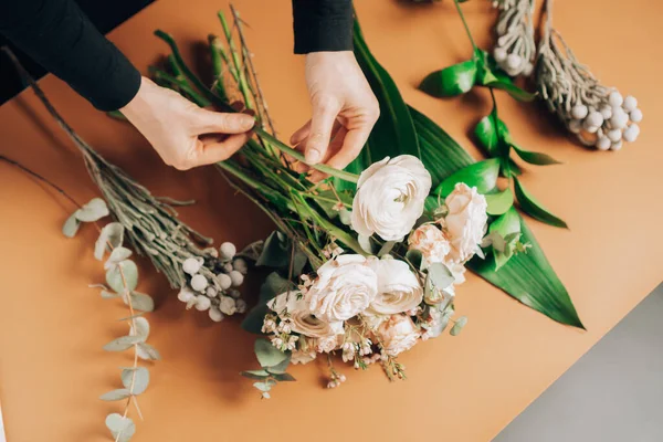 Mix of flowers on the florist\'s table. Florist makes a bouquet of Mix flowers. The process of making a beautiful elegant bouquet.