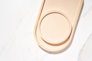 Güzellik kozmetik ürünleri sunumu bej şekilli düz maket sahnesi beyaz mermer masa üzerinde fotokopi alanı ile. Moda güneş ışığı, üst manzara. Stüdyo fotoğrafçılık.