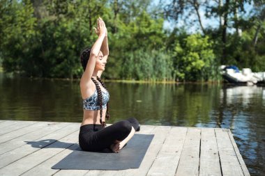 Hint yogası güzel Hintli kadınla nehir kıyısında meditasyon yapıyor..