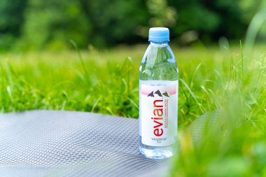 Meşhur Fransız Evian su şişesinin, çayırdaki Fitnes minderinin üzerindeki illüstrasyon başyazısı. Evian, Fransız kaliteli su markasıdır. POLTAVA, UKRAINE - Haziran 08, 2023.