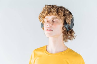 Genç kıvırcık saçlı, kulaklıklı adam. Yakın plan portre.