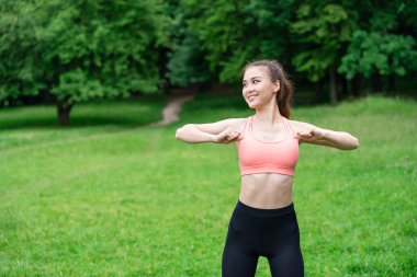 Açık bir yaz otlağında doğa ile tenha, zinde bir kızla sabah egzersizi. Sabahın erken saatlerinde spor yapan bir fitness meraklısı, sakin yaz çayırlarının güzelliğiyle çevrili, açık havada..