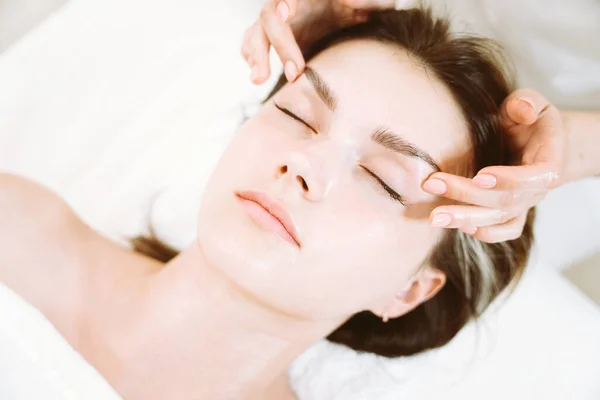 Lymphatic drainage facial and eyes zone massage by professional massage therapist in clinic