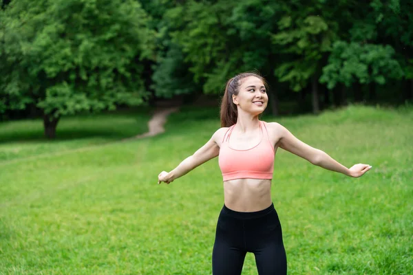 Morning exercise with fit girl secluded with nature in a summer meadow outdoors. Early morning workout with a fitness enthusiast, surrounded by beauty of serene summer meadow in the great outdoors.