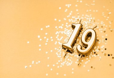 19 yıllık kutlama arkaplanı altın mumla süslenmiş. On dokuz numara ışıldıyor. Kopya alanı olan evrensel bayram afişi.
