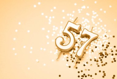 57 yıllık kutlama arkaplanı altın mumla yapılmış 57 numaralı ışıltı şeklinde. Kopya alanı olan evrensel bayram afişi.