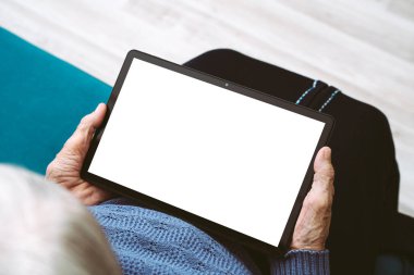 Metnin ya da tasarımın için boş beyaz ekran içeren tablet bilgisayarı tutan yaşlı bir kadının kırışık elleri