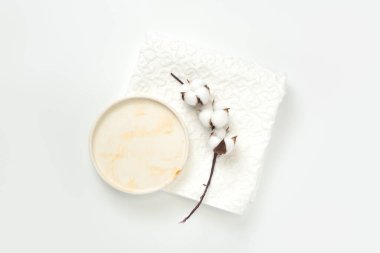 Güzellik kozmetik ürünleri sunumu düz sahne düzenleme daire tepsisi ve beyaz havlu üzerinde pamuk çiçek dalı ile yapılmıştır.