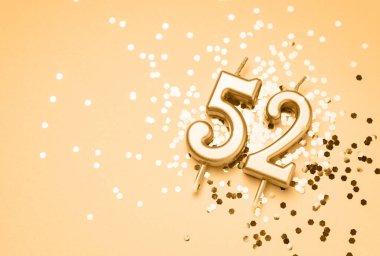 52 yıllık kutlama arkaplanı altın mumla süslenmiş 52 numara pırıltı üzerinde yatıyor. Kopya alanı olan evrensel bayram afişi.