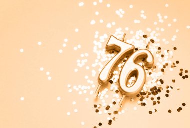 76 years celebration festive background made with golden candles in the form of number Seventy-six lying on sparkles. Universal holiday banner with copy space. clipart