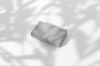 Taş podyumdan yapılmış kozmetik ürünleri sunumu sahnesi ve beyaz arka planda gölgeler bırakıyor. Güzellik ve kozmetik ürünlerini sergilemek için ideal. Görünümün üstünde.