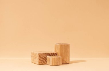 Bej arka planda desenli ahşap küp kaidesi üzerine kurulmuş güzellik kozmetik ürünleri sergilenen bir maket sahnesi. Bir stüdyo ortamında yakalandı..