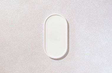 Güzellik kozmetik ürünleri sunumu düz bir sahneydi. Kopyalama alanınız için dokulu yüzeydeki beyaz oval tepsiyle yapılmıştı. Stüdyo fotoğrafçılık.