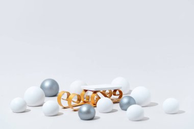 Beyaz Arkaplanda Altın Kızak Podyumu ve Gümüş Süslemeleri olan zarif Noel Ürünleri Sunumu. Minimalist Bayram Pazarlama ve Sezonluk Tanıtımlar Sahnesi.