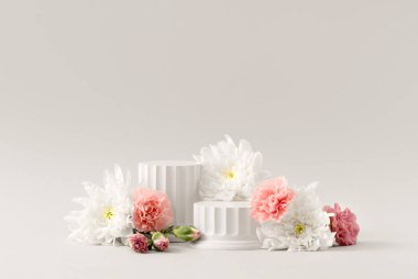 Beyaz Arkaplanda Beyaz Sütunlar ve Doğal Çiçekler ile Güzellik Kozmetik Ürünleri Sunumu Podyumu. Stüdyo Fotoğrafçılığı.