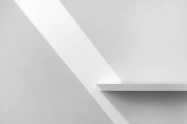 Güzellik kozmetik ürünleri sunumu sahnesi boş beyaz raftan yapılmış ve üzerinde güneş ışığı var. Ürün yerleştirme için mükemmel. Stüdyo fotoğrafçılık.