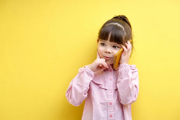 Funny child girl talking on phone with someone, thinking. Caucasian kid looking at side, concentrated in thought. portrait of child having serious talk