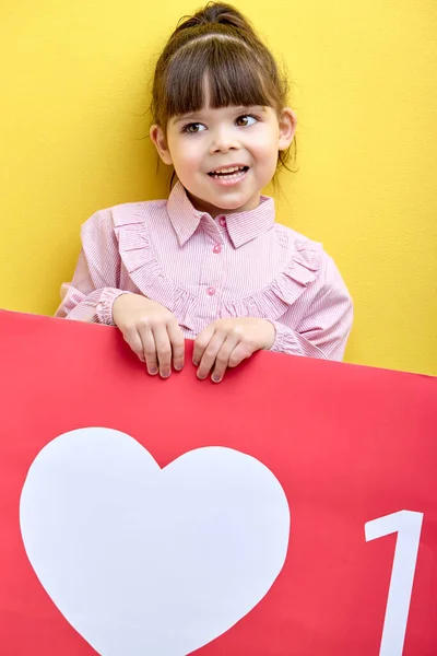 happy little girl want more likes and attention in blog, portrait of young blogger with like heart sign. internet, blogging, children, people lifestyle concept