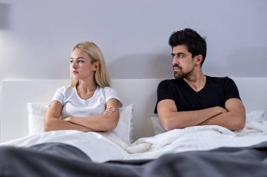 Young couple life is not happy in the marriage. Quarrel of a young couples life. Man and woman dont understand each other, sit ignoring. Crisis and relationship problems that come to an end.