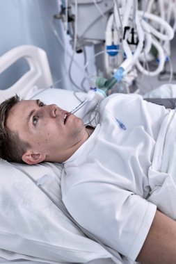 Genç yaralı bir adam, sağlık hizmetleri konseptinde geçirdiği kazadan sonra kötü sağlık durumundan dolayı acıdan dinleniyor.