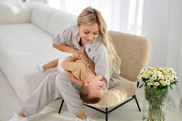 european mom and child at home in living room. Mom and kid boy playing in sunny cozy room. Parent and little kid relaxing at home. Family having fun together. At weekends, leisure time