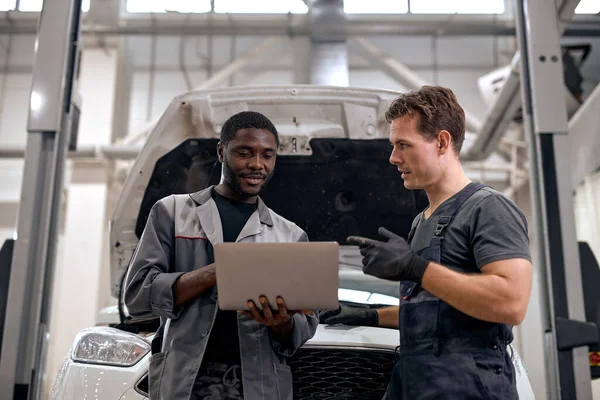 Black Car Mechanic Caucasian Repairman Checking Diagnose Ergebnisse Auf Laptop — Stockfoto