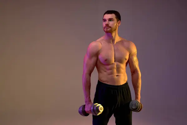 真剣な野心的なスポーツマン ダンベルを見上げて 肖像画を閉じる 強度トレーニング 健康的なライフスタイル — ストック写真