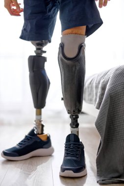 Tanımlanamayan, spor ayakkabılı bir adam evde yerde duruyor, yeni bir hayata başlıyor, yapay bacağa alışmaya çalışıyor. Asla pes etme. engellilik kavramı