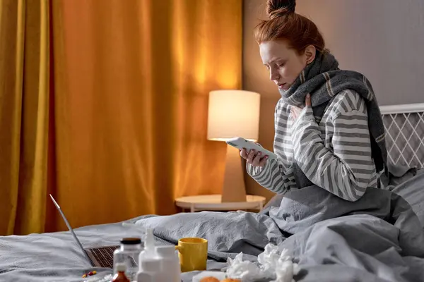 여자는 그녀의 전화를 침실에서 침대에 클로즈업 초상화 정보를 자신을 로열티 프리 스톡 이미지