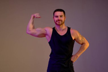 Dövmeli neşeli, yakışıklı adam kameraya bakıyor, portre, sağlık ve vücut bakımı yakın çekim. Boş zaman, boş zaman, yaşam tarzı. izole kahverengi arkaplan