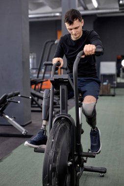 Genç adam bacaklar, kollar, kaslar, yanan kaloriler için egzersiz yapıyor.