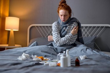 Genç hasta kızıl kadın kalp krizi geçiriyor, yalnız kadın kendini kucaklıyor, geceleri üşüyor. humma portreyi kapat