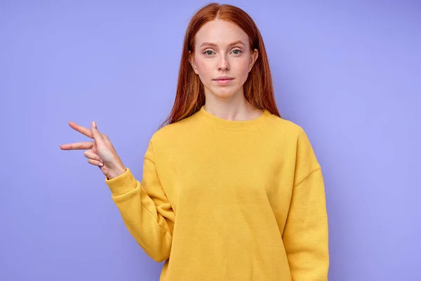 letter K spelling by girls hand in American Sign Language ASL on blue background, closeup portrait, confident Caucasian woman demonstrating the letter K. sign language symbol for deaf human