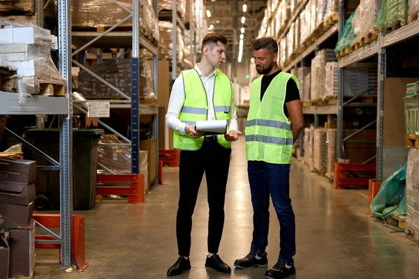 Men Warehouse Workers Talking Holding Document Paper Two Young Workers — Stock Photo, Image