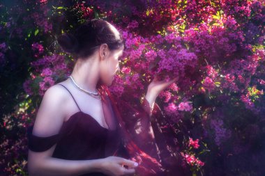 Güzel bir çalılığın bahar dalını tutan genç bir kadının klasik portresi..