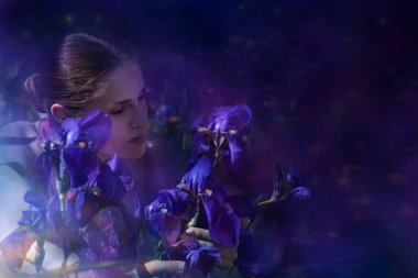 A woman gently touches Iris flowers in a close emotion. clipart