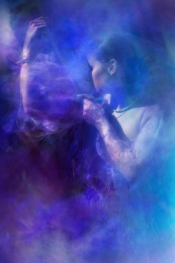 Çekici genç bir kadın, kollarının üzerine şeffaf, şeffaf ışık dokularıyla peçeler takıyor..