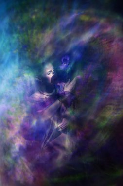 Bir Iris çiçeğini sımsıkı tutan genç bir kadın, güneş ışığı atmosferinde doğayla olan bağlantısını dışa vuruyor..