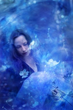 Hayal kuran bir dişi, yine Windflowers olarak da bilinen Anemones 'a sakin bir ruh haliyle dokunuyor..