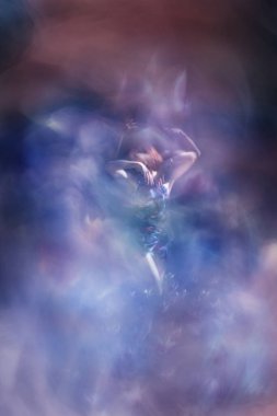 Güzelce giyinmiş kadın dansçı, birden fazla katmanlı pozlar, büyük bir lale tomurcuğunu hatırlatıyor..