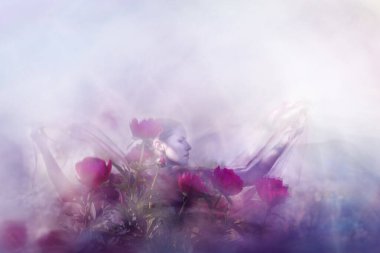 Ellerinde şeffaf peçeleri olan, çift pozlu bir dansçı açık kollarla poz veriyor..