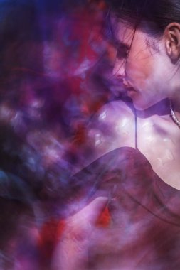 Renklere karşı tutkulu bir kadın etrafında şakayık yaprak dokuları uçuşan hareketli anlarda enerjisini ifade ediyor..